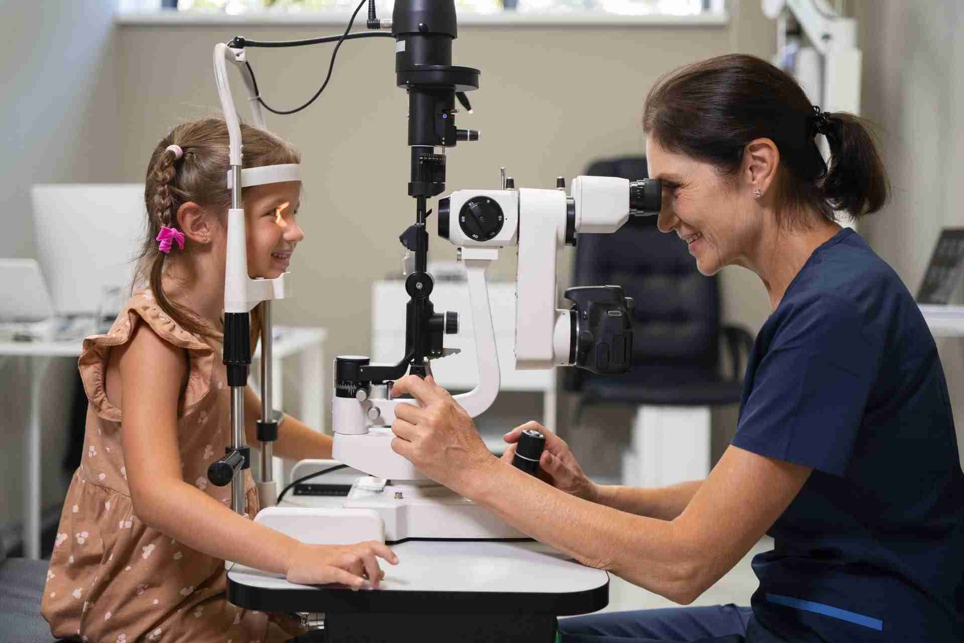 Female optometrist conducting slit lamp examination on young patient in vision clinic